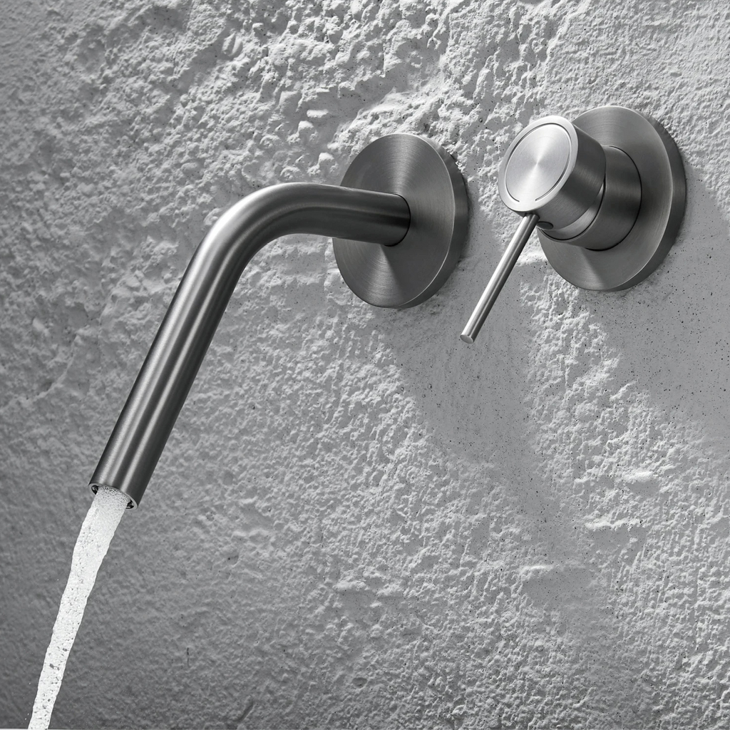 Cortenvale ARCUS wall-mount bathroom tap with curved spout in Brushed Brass and Gunmetal — solid brass, WRAS approved