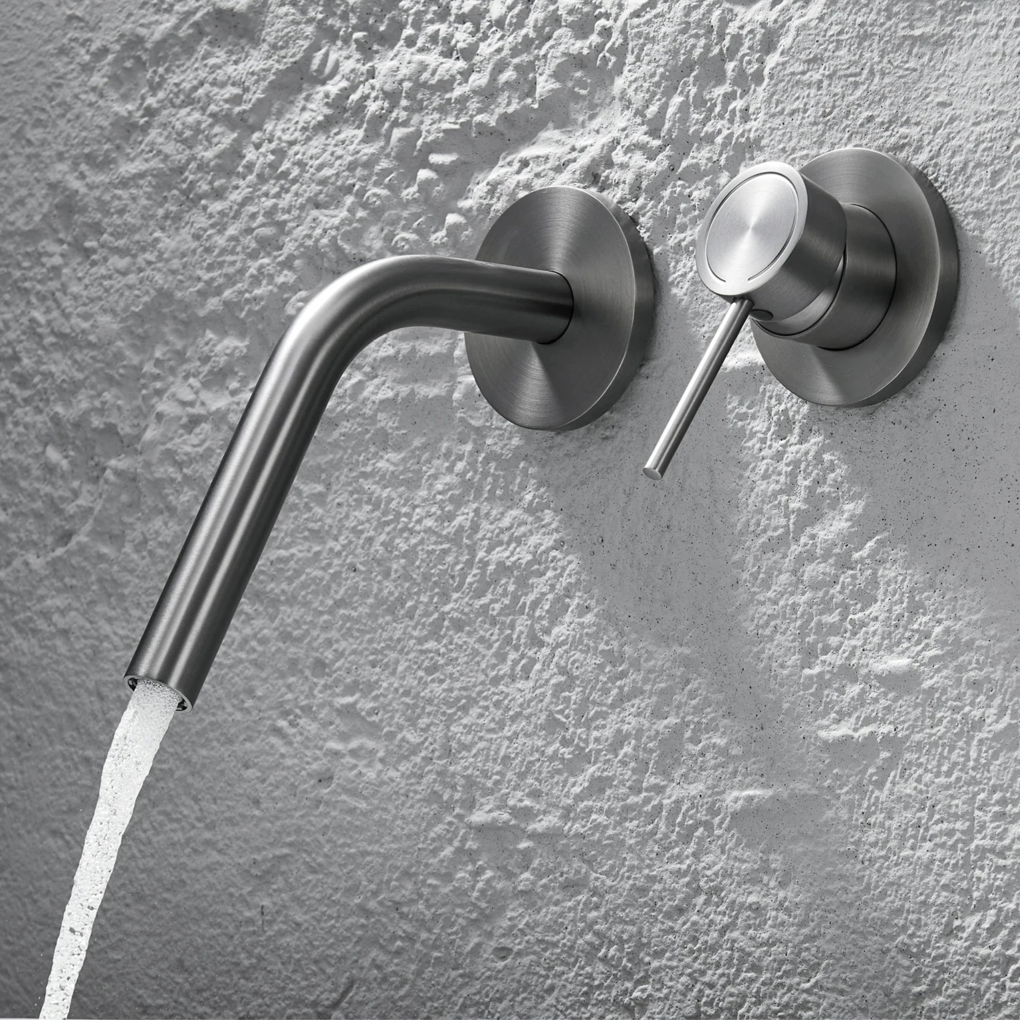 Cortenvale ARCUS wall-mount bathroom tap with curved spout in Brushed Brass and Gunmetal — solid brass, WRAS approved